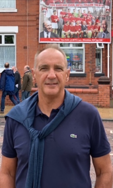 Jim Palm in a navy polo shirt outside Old Trafford